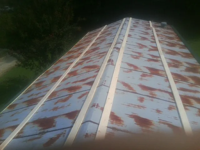 Rusted metal roof panels with new wood purlins before replacement — Storm Damage Roof Repair in North Olmsted by Roofing Brothers