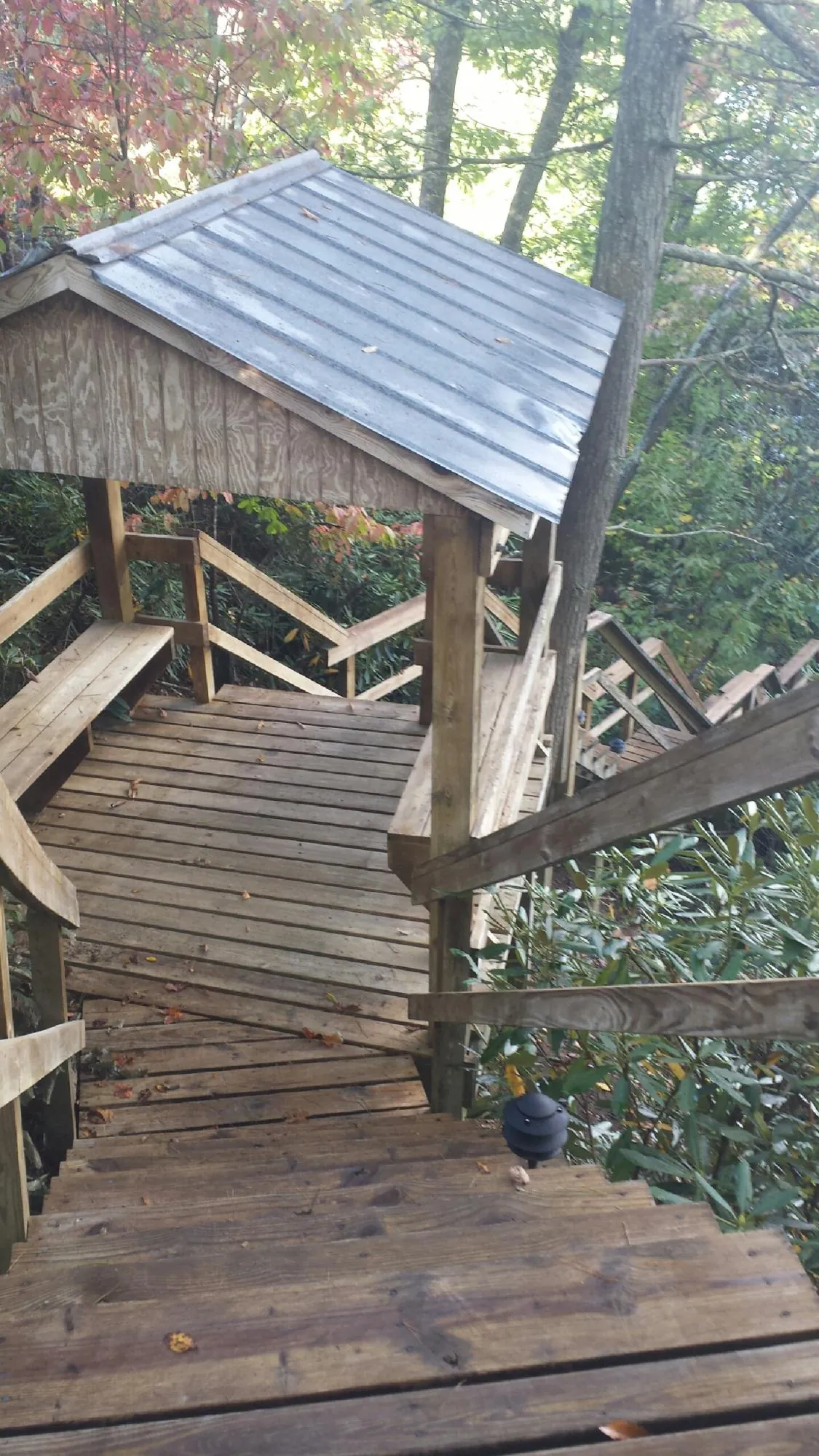 Metal roofed shelter over wooden steps on a wooded walkway — Skylight Repair & Installation work by our crew in North Olmsted