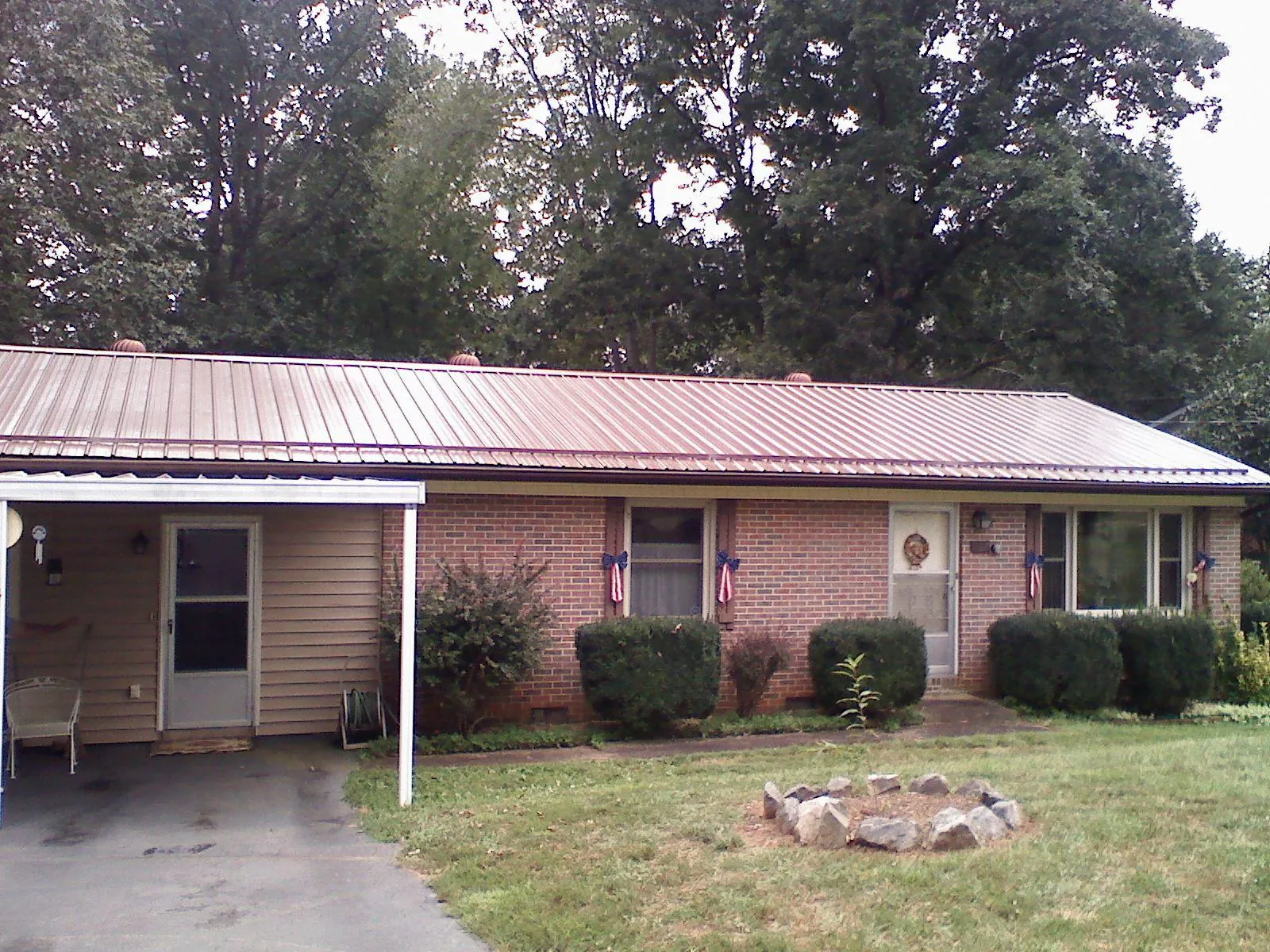 Bronze metal roof and carport on a brick ranch home — Roof Repair work by our crew in North Olmsted